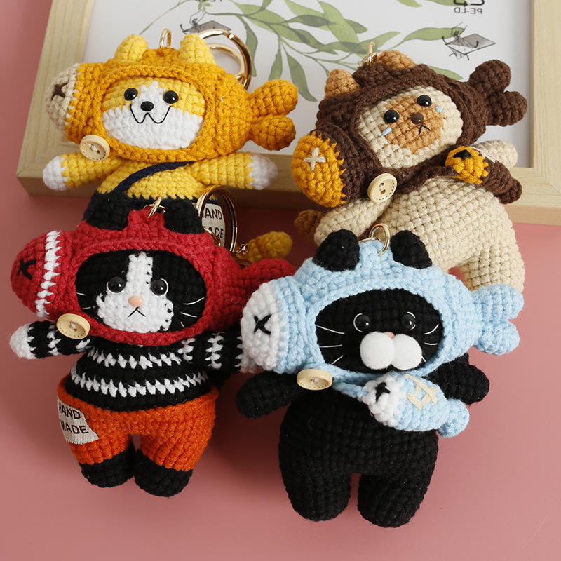 Assorted crochet cat and bear keychains wearing playful fish-shaped hoods