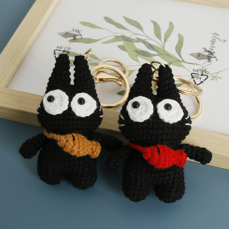 Two original big-eyed black cat crochet keychains with colorful neck bows