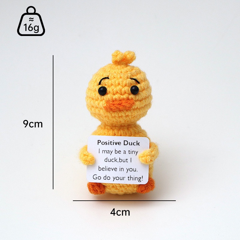 Small positive duck crochet companion holding an encouraging message card